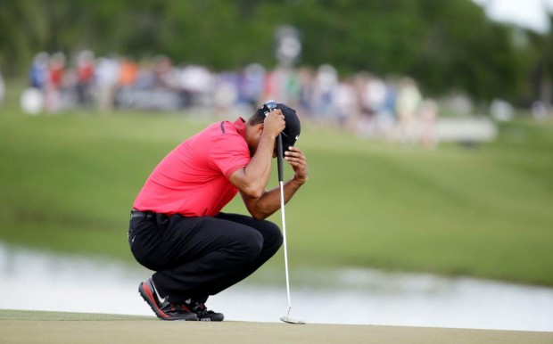 Tiger Woods bows his head on the fourth green during the final round of the Cadillac Championship golf tournament on Sunday, March 9, 2014, in Doral, Fla. Woods made bogey on the hole. (AP Photo/Lynne Sladky)