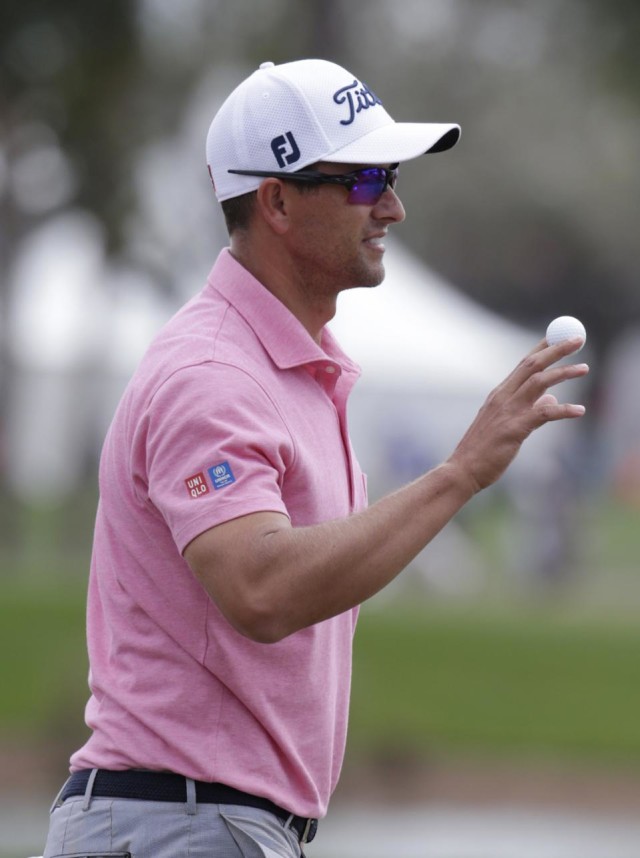 Adam Scott, of Australia, holds up the ball after a birdie putt on the first hole during the fourth round of the Honda Classic golf tournament, Sunday, Feb. 28, 2016, in Palm Beach Gardens, Fla. (AP Photo/Lynne Sladky)