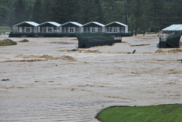 This Thursday June 23, 2016 image provided by the Greenbrier shows flooding on the 17th green of the Old White Course at the Greenbrier in White Sulphur Springs, W. Va. Severe flooding hit the area that is scheduled to host a PGA tour event in two weeks. (Cam Huffman/The Greenbrier via AP)