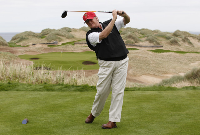 U.S. property magnate Donald Trump practices his swing at the 13th tee of his new Trump International Golf Links course near Aberdeen